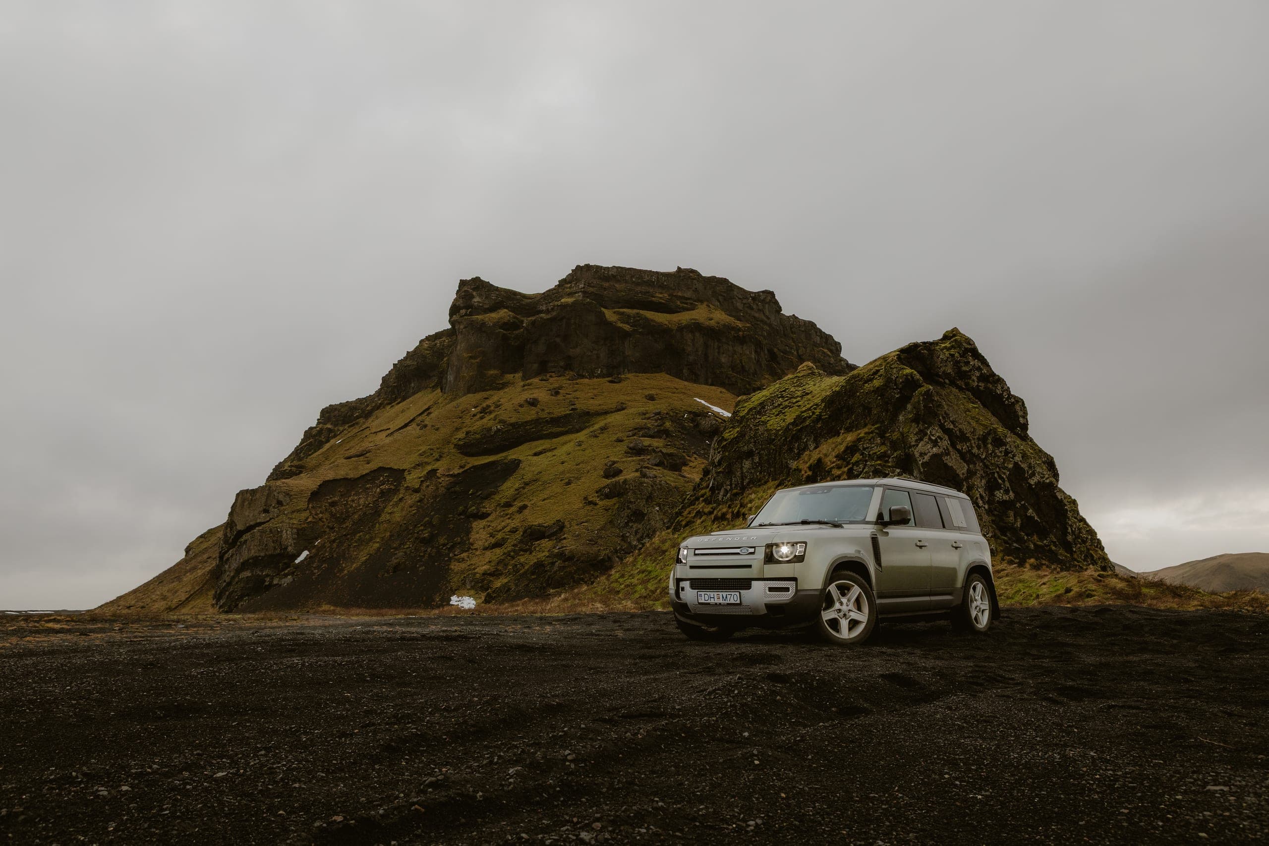 Defender vor dramatischer Felslandschaft